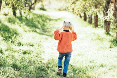 Portrait of sweet little blonde girl playing in sun outdoors. Happy little child having fun at park. Laughing child. Expressive facial with cute expression.