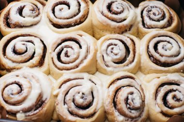 Krem peynir soslu taze pişmiş tarçınlı çörekler. Tarçınlı ev yapımı rulo. Seçici odaklanma. Fransız çörekleri, salyangoz tarçınlı ve kremalı.