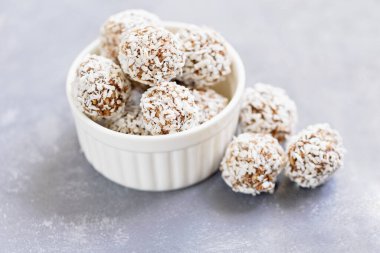 Sağlıklı çiğ enerji topları, kakao, hindistan cevizi, susam, beyaz arka planda chia. Yuvarlak yulaf, fındık ve hurma içeren sağlıklı ev yapımı paleo çikolata enerji topları. Çiğ vejetaryen sağlıklı tatlı, seçici odaklanma