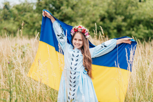 Ukraines Independence Flag Day. Constitution day. Ukrainian child girl in embroidered shirt vyshyvanka with yellow and blue flag of Ukraine in field. flag symbols of Ukraine. Kyiv, Kiev day