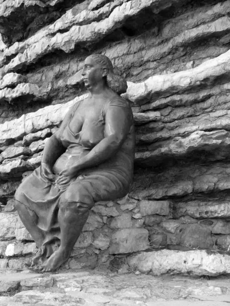 stock image Portovenere, La Spezia, Liguria, Italy - 06-10-2018 - The artistic representation of a woman sitting on the rocks waiting for the fishermen to return from the sea