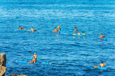 LA SPEZIA, İtalya - 28 Temmuz 2022: Güneşli bir yaz gününde, mavi Akdeniz 'de büyük bir kano grubu. Tellaro Köyü, La Spezia Körfezi, Liguria, İtalya, Güney Avrupa.