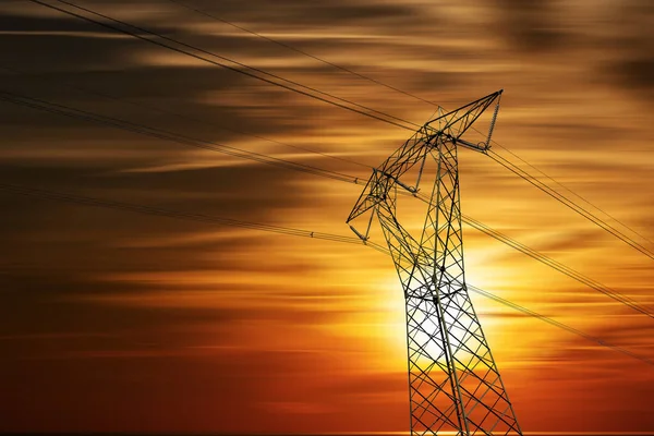雲とコピースペースで日没の美しい空に対する高電圧塔 電線や絶縁体と電源ラインの写真 — ストック写真