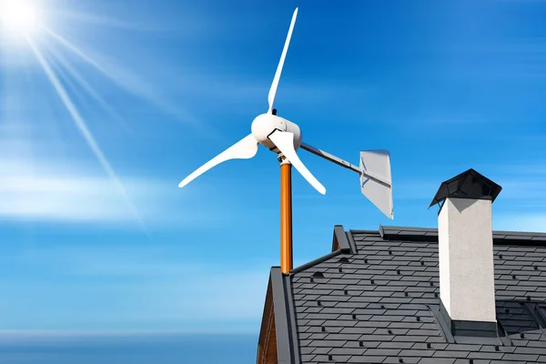 房子屋顶上的一个小型风力涡轮机的特写 在乌云和太阳光的蓝天下 可再生能源概念 免版税图库照片
