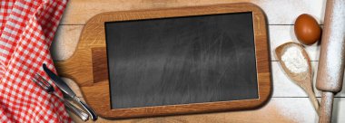 Ahşap bir masa üzerinde (merdane, beyaz un, yumurta, gümüş çatal bıçak ile kaşık) eski ahşap kesim tahtasının içinde boş bir karatahta. Tarifler ya da yiyecek ve içecek menüsü şablonu.