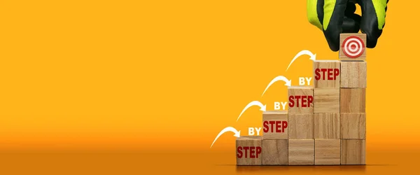 ステップ ステップとテキスト ステップの最後のステップとターゲット シンボルを持つステップ 階段として木製のブロックを配置する手袋をはめた手 成功や目標の概念のはしご コピースペース付きオレンジと黄色の背景 — ストック写真