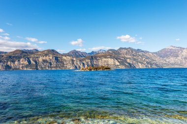 Garda Gölü (Lago di Garda) ve İtalya 'nın güneyindeki Malcesine, Verona ili, İtalya, Veneto, Güney Avrupa' nın küçük bir köyü. Arka planda Lombardy kıyısı ve zeytin adası.
