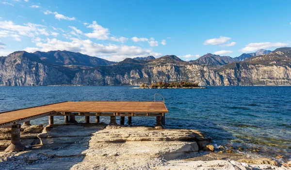 ガルダ湖 Lago Garda とイタリアアルプスのビーチと木製の桟橋は マルセシーヌの小さな村からの眺め ヴェローナ県 イタリア ヴェネト州 南ヨーロッパ ロンバルディア州の海岸を背景に — ストック写真
