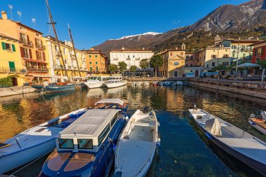 Malcesine köyünün küçük limanında küçük tekneler demirlemiş. Garda Gölü kıyısındaki ünlü turizm beldesi (Lago di Garda). Verona, Veneto, İtalya, Avrupa. Monte Baldo 'nun sıradağları.