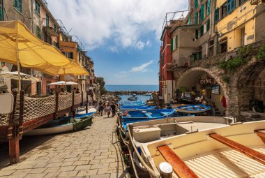 RIOMAGGIORE, ITALY - JULY 8, 2021: The famous Riomaggiore village with the small port with many small boats, Cinque Terre National Park in Liguria, La Spezia, Italy, Europe. UNESCO world heritage site
