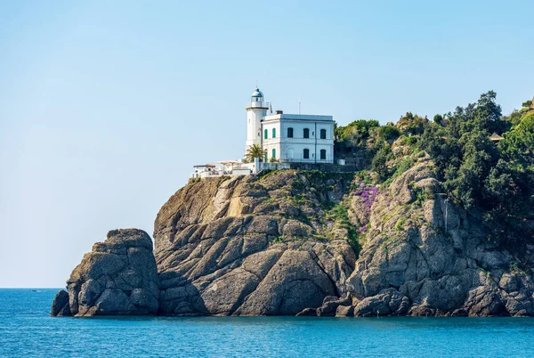 stock image Coast of the Mediterranean Sea (Ligurian Sea) with old white lighthouse. Port of Portofino village, Genoa province (Genova), Liguria, Italy, Europe.