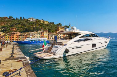 PORTOFINO, İtalya - 8 Nisan 2023: lüks yatı ve demirli bir turist feribotu olan güzel Portofino limanı. Cenova Eyaleti, Liguria, İtalya ve Avrupa 'daki lüks turizm beldesi.