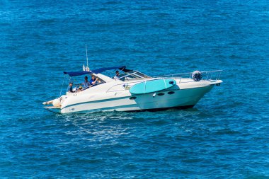 LA SPEZIA, İtalya - 27 Temmuz 2022: güneşli bir yaz gününde insanlarla birlikte mavi Akdeniz 'de beyaz lüks bir motorlu tekne. La Spezia Körfezi, La Spezia, Liguria, İtalya, Avrupa.