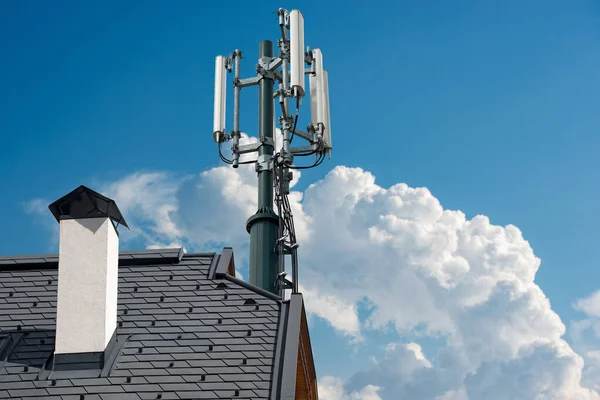 アンテナ 付き電気通信塔付きの家の屋根の閉鎖 雲とコピースペースを持つ澄んだ青い空に対して — ストック写真