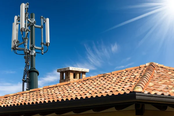 带有天线 的电信塔的房屋屋顶的闭合 与蓝天的云彩相映成趣 — 图库照片
