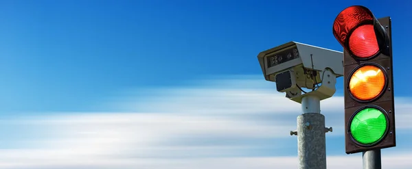 Closeup of a traffic light and a traffic control camera against a clear blue sky in motion with copy space.