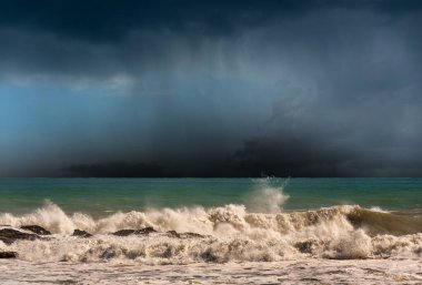Fırtına bulutları (cumulonimbus) ve sağanak yağmurlu dalgalı deniz. Akdeniz (Ligurya Denizi), La Spezia Körfezi, Liguria, İtalya, Avrupa.