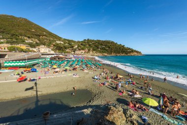 BONASSOLA, İtalya - 2023: Bonassola plajı güneşli bir yaz gününde, Ligurian sahilindeki küçük bir kasaba ve turist beldesinde turistlerle dolup taşıyor. La Spezia ili, Liguria, İtalya, Avrupa.