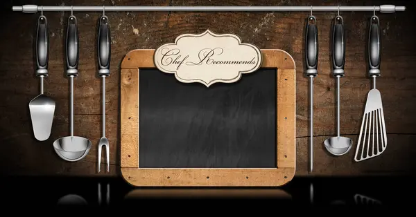 Empty blackboard with wooden frame with copy space and a label with text Chef Recommends, set of kitchen utensils made of stainless steel and black plastic on a wooden wall.