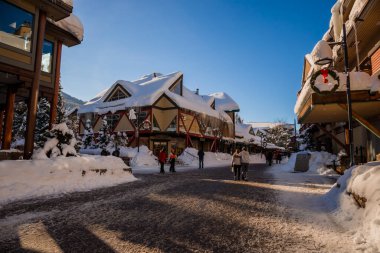 Bir kış masalı - Noel için güneşli bir gün. Karla kaplı sokaklar, evler, güneş ışınları, yaya bölgesinde yürüyen insanlar. Kayak merkezi, kışın Olimpiyat oyunları Whistler, Kanada