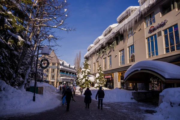 Bir kış masalı - Noel için güneşli bir gün. Karla kaplı sokaklar, evler, güneş ışınları, yaya bölgesinde yürüyen insanlar. Kayak merkezi, kışın Olimpiyat oyunları Whistler, Kanada