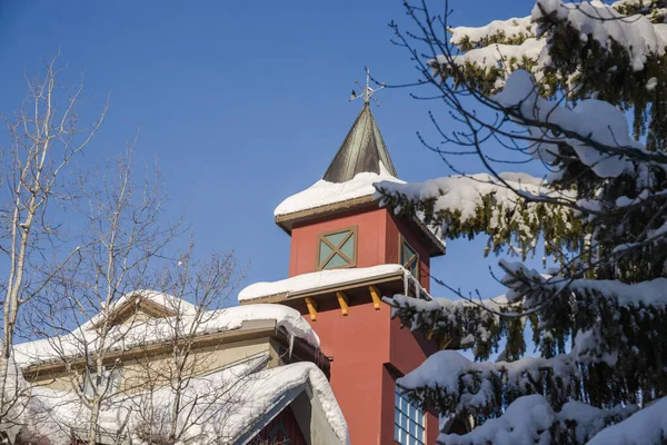 冰雪覆盖的建筑物 屋顶上的雪堆 美丽的冰柱 时钟被雪覆盖着 寒冷但晴朗的冬日 加拿大Ski度假胜地 — 图库照片