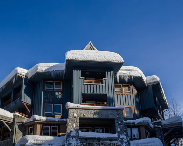 冰雪覆盖的建筑物 屋顶上的雪堆 美丽的冰柱 时钟被雪覆盖着 寒冷但晴朗的冬日 加拿大Ski度假胜地 — 图库照片