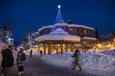 Bir dağ köyünde muhteşem bir akşam. Kar yığınları, Noel ışıkları, gece ışıkları, karla kaplı evler. Sihirli bir kış. 