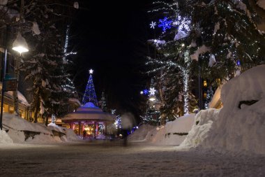 Bir dağ köyünde muhteşem bir akşam. Kar yığınları, Noel ışıkları, gece ışıkları, karla kaplı evler. Sihirli bir kış. 