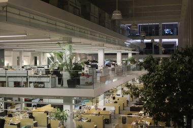 Üzerinde masaüstü duran bilgisayar tablolarından oluşan rahat işyerleri olan modern açık uzay bürosu