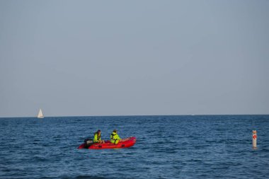  Two lifeguards in a lifeboat patrol the beach. Safety on the water. Special services. sailing in an inflatable boat to rescue people in distress.