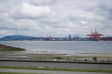 North Vancouver - mountains, bay, Cargo warehouse - industrial port, cargo ship. beautiful clouds and the sea. Travel in the summer.