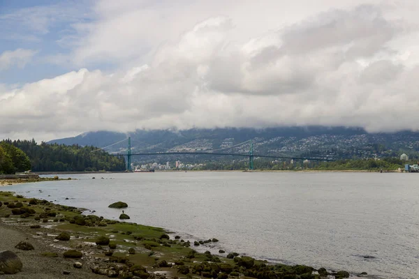 North Vancouver - mountains, bay, Cargo warehouse - industrial port, cargo ship. beautiful clouds and the sea. Travel in the summer.