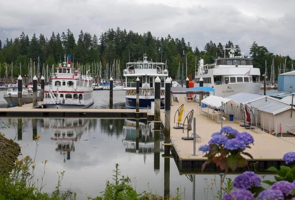 Summer trip across America - Stanley Park waterfront, downtown Vancouver, harbor with yachts and boats, skyscrapers and nature. Calm water of the bay.
