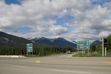 Highway in mountains. Trans Canada Highway with a perfect asphalt at sunrise in summer.  Banff National Park, Alberta, Canada. Travel background. Tourism hiking - a road in the forest between the mountains. Great view, summer vacation, 