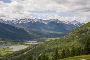 Rocky mountains in summer - a wonderful day, summer, cloudy with clearings. green meadows, coniferous forest, and lakes.