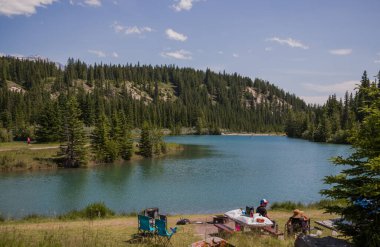  Tahta köprüsü olan çağlayan göletler. Uzakta Rundle Dağı 'nın olduğu piknik alanı Banff Ulusal Parkı, Alberta, Kanada