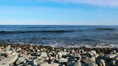 Arka planda mavi gökyüzü olan deniz manzarası. Hafif okyanus dalgaları, seçici odak, ön planda bulanık taşlar - Atlantik kıyısı - Halifax, Kanada