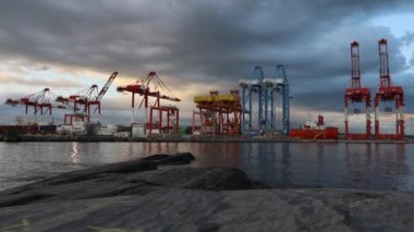 Gün batımında kargo gemisinde çalışıyor. Küresel nakliye konteynır iskelesi - vinçler kargo gemisini yüklüyor. Halifax, Nova Scotia, Kanada 'da sanayi bölgesi