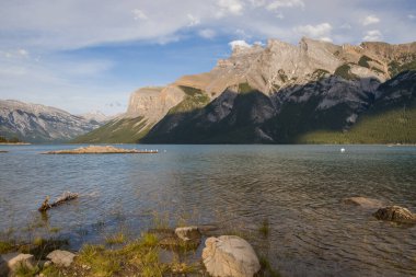 Minnewanka Gölü - bulutlu gökyüzü, dağlar ve temiz kaynak suyu, Banff Ulusal Parkı, Alberta, Kanada