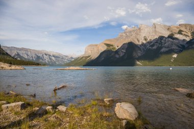 Minnewanka Gölü - bulutlu gökyüzü, dağlar ve temiz kaynak suyu, Banff Ulusal Parkı, Alberta, Kanada