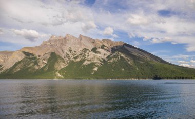 Minnewanka Gölü - bulutlu gökyüzü, dağlar ve temiz kaynak suyu, Banff Ulusal Parkı, Alberta, Kanada