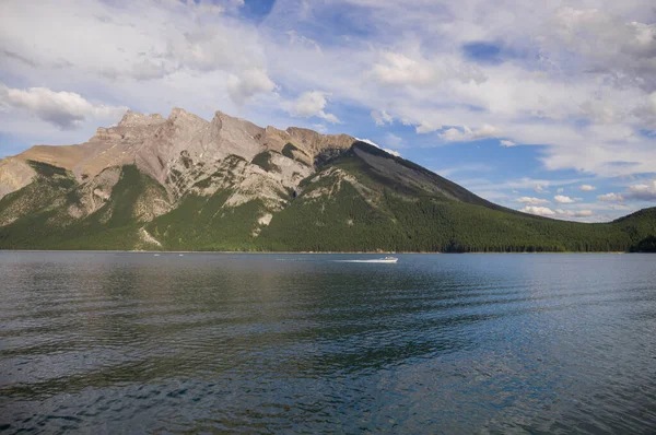 stock image Active recreation - canoes, kayaks, boat cruise - tourist point on the lake Minnewanka. Mountain tourism, Banff National Park, Alberta, Canada