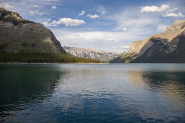 Dağ Gölü manzarası manzarası insanları - orman, manzaralı mavi göl ve ufukta Rocky Dağları. Minnewanka Gölü, Banff il parkı, Alberta, Kanada