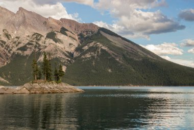 Dağ Gölü manzarası manzarası insanları - orman, manzaralı mavi göl ve ufukta Rocky Dağları. Minnewanka Gölü, Banff il parkı, Alberta, Kanada