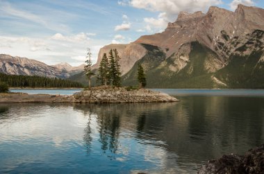 Dağ Gölü manzarası manzarası insanları - orman, manzaralı mavi göl ve ufukta Rocky Dağları. Minnewanka Gölü, Banff il parkı, Alberta, Kanada