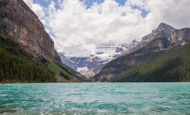 Dağ Gölü manzarası manzarası insanları - orman, manzaralı mavi göl ve ufukta Rocky Dağları. Minnewanka Gölü, Banff il parkı, Alberta, Kanada