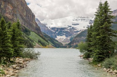 Dağ Gölü manzarası manzarası insanları - orman, manzaralı mavi göl ve ufukta Rocky Dağları. Minnewanka Gölü, Banff il parkı, Alberta, Kanada