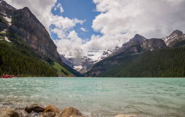 Banff Ulusal Parkı 'nda Louise Gölü, Alberta, Kanada. Louise Gölü karla kaplı dağ tepeleri, kozalaklı orman ve mavi buzul gölü, bulutlu bir gün. konsept - dağ turizmi. Boşluğu kopyala 