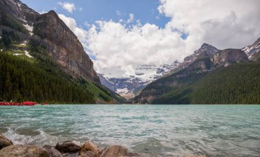 Banff Ulusal Parkı 'nda Louise Gölü, Alberta, Kanada. Louise Gölü karla kaplı dağ tepeleri, kozalaklı orman ve mavi buzul gölü, bulutlu bir gün. konsept - dağ turizmi. Boşluğu kopyala 